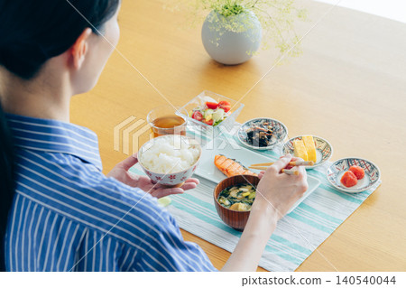 A young woman's hands as she eats breakfast at home A young woman's hands as she eats breakfast at home 140540044
