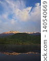 The sunrise over Ichinose Park in Norikura Highlands, with a view of Mount Norikura reflected in the water from Maime Pond. 140540669