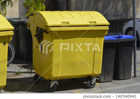 Yellow Plastic Recycling Container on Street Side Yellow Plastic Recycling Container on Street Side 140540941