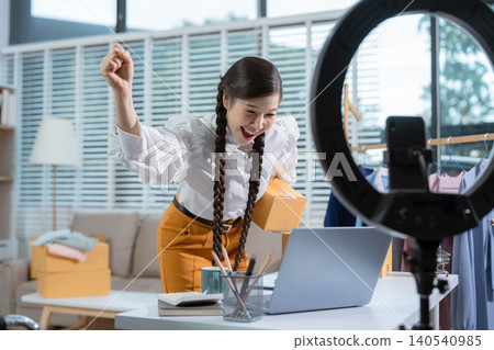 Happy businesswoman smiling at sales success after checking profits from home online store, concept of online commerce and e-commerce. Happy businesswoman smiling at sales success after checking profits from home online store, concept of online commerce and e-commerce. 140540985