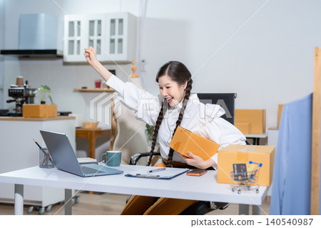 Happy businesswoman smiling at sales success after checking profits from home online store, concept of online commerce and e-commerce. Happy businesswoman smiling at sales success after checking profits from home online store, concept of online commerce and e-commerce. 140540987