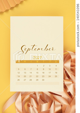 September 2027 calendar page with yellow ribbon on yellow background. September 2027 calendar page with yellow ribbon on yellow background. 140541096