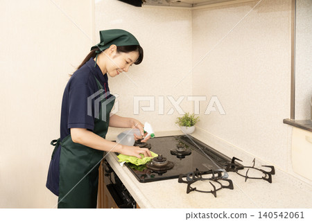 House cleaning woman cleaning the gas range 140542061