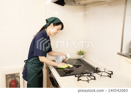 House cleaning woman cleaning the gas range House cleaning woman cleaning the gas range 140542065
