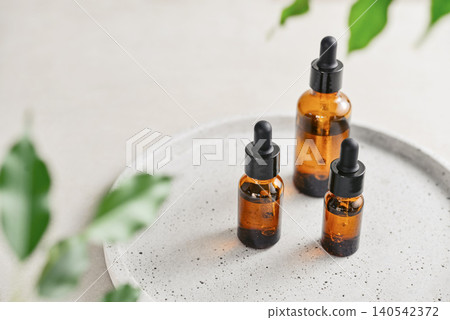 Natural skincare and beauty treatment concept with amber glass cosmetic containers arranged on a round tray. Natural skincare and beauty treatment concept with amber glass cosmetic containers arranged on a round tray. 140542372