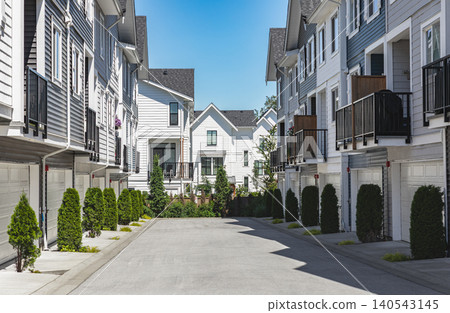 New townhouses in residential comfortable neighborhood on a sunny day. Real Estate Exterior Front Homes with garages in suburbs North America. Modern apartment buildings. Housing development New townhouses in residential comfortable neighborhood on a sunny day. Real Estate Exterior Front Homes with garages in suburbs North America. Modern apartment buildings. Housing development 140543145