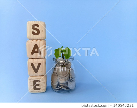 Coins in a glass with growing plant seeds and a cube with the word save written on it. The concept of save money or saving money. Coins in a glass with growing plant seeds and a cube with the word save written on it. The concept of save money or saving money. 140543251