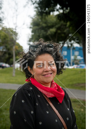 A woman wearing a red bandana and sunglasses is smiling 140543375