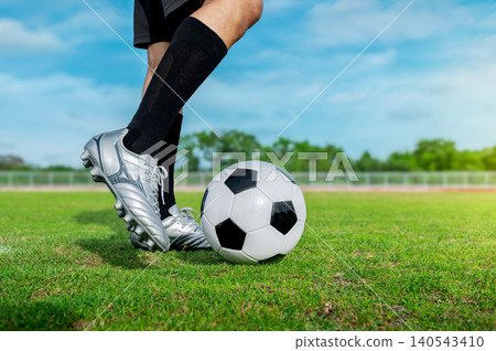 Extreme Close-up of Football Cleats and Ball: Professional Sports Equipment Background with Copy Space Extreme Close-up of Football Cleats and Ball: Professional Sports Equipment Background with Copy Space 140543410