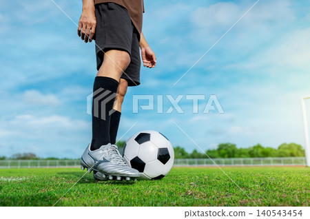 Close-up of Soccer Player Feet in Silver Cleats Ready to Kick Football on Green Grass Pitch Close-up of Soccer Player Feet in Silver Cleats Ready to Kick Football on Green Grass Pitch 140543454
