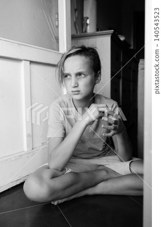Bored Teenager Sitting on Floor with Thoughtful Look Bored Teenager Sitting on Floor with Thoughtful Look 140543523