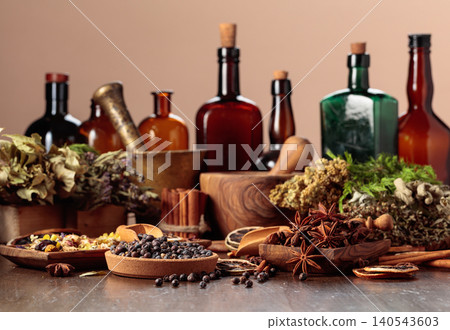 Rustic still life with vintage bottles, medicinal herbs, juniper berries and fragrant spices. 140543603