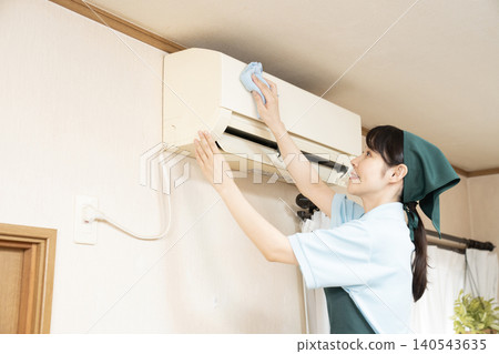 Female worker cleaning the house to clean the air conditioner Female worker cleaning the house to clean the air conditioner 140543635