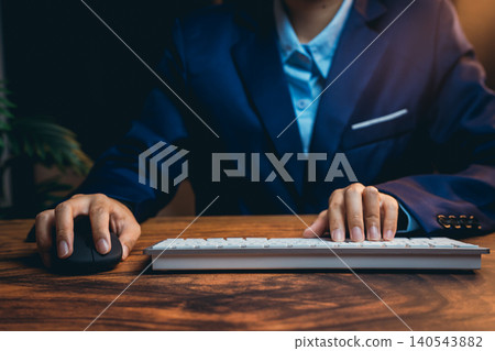 Professional Business Person Working at Desk with Keyboard and Mouse in Office Setting 140543882