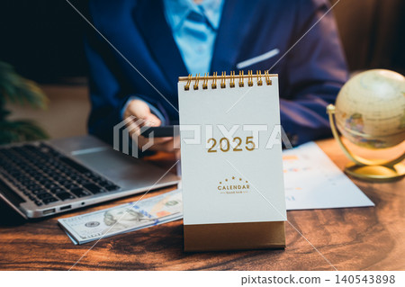 Businessman Planning Future Goals with Calendar and Money on Desk in Modern Office Setting 2025 140543898