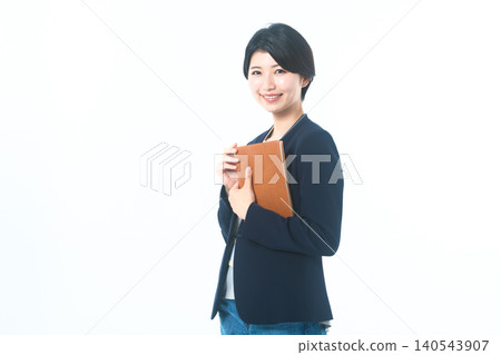 一位女商人面帶微笑，手裡拿著一個文件夾。 140543907