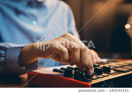 Pianist concept. Close-Up of Hands Adjusting Knobs on Music Production MIDI Controller for Electronic Music Creation Pianist concept. Close-Up of Hands Adjusting Knobs on Music Production MIDI Controller for Electronic Music Creation 140544191