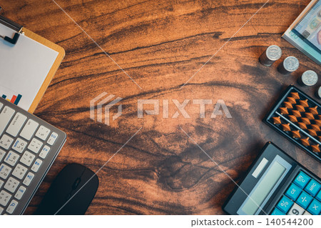 Business concept. Workspace with calculator, keyboard, clipboard, and coins on wooden desk for financial planning and analysis Business concept. Workspace with calculator, keyboard, clipboard, and coins on wooden desk for financial planning and analysis 140544200