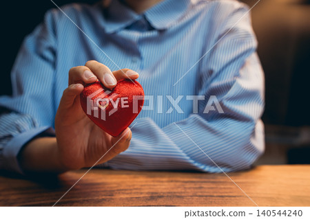 Love concept. Close-Up of Hand Holding a Red Heart Symbolizing Love with a Soft Focus Background Love concept. Close-Up of Hand Holding a Red Heart Symbolizing Love with a Soft Focus Background 140544240