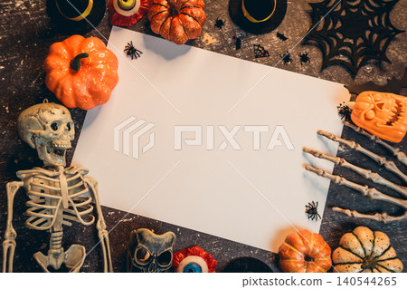 Halloween flat lay. Halloween Decoration with Pumpkins, Skeleton, Spiders, Candles, and Blank Paper for Creative Ideas 140544265