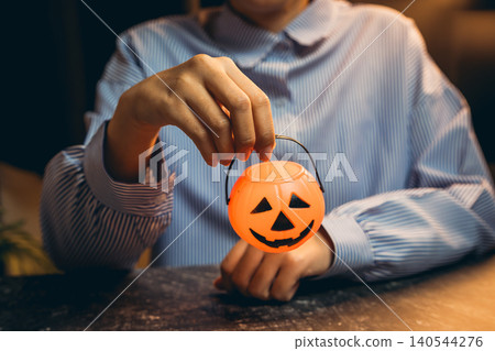 Halloween prop concept. Person Holding a Cute Pumpkin Shaped Candy Container for Halloween Celebration and Festive Decoration Ideas Halloween prop concept. Person Holding a Cute Pumpkin Shaped Candy Container for Halloween Celebration and Festive Decoration Ideas 140544276