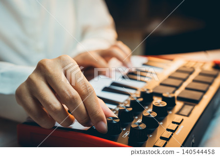 Pianist Concept. Close-Up View of a Music Producer Playing MIDI Keyboard with Creative Focus and Artistic Passion in a Studio Environment Pianist Concept. Close-Up View of a Music Producer Playing MIDI Keyboard with Creative Focus and Artistic Passion in a Studio Environment 140544458