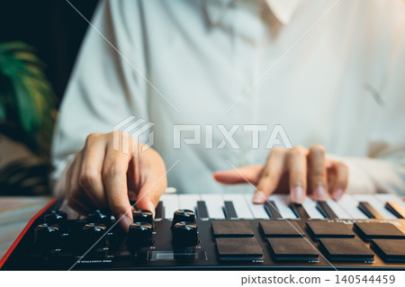 Pianist Concept. Person Playing Electronic Keyboard with Focused Expression While Creating Music in a Comfortable Setting 140544459