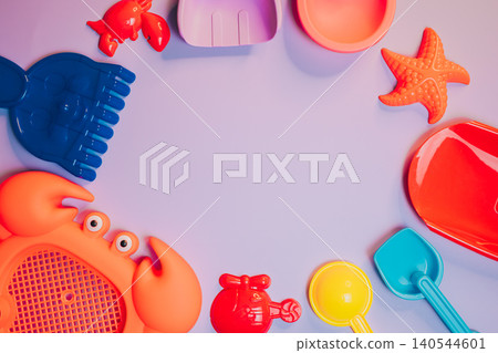 Summer flat lay. Colorful Plastic Beach Toys and Accessories for Summer Fun with Crabs, Starfish, and Sandcastle Tools Summer flat lay. Colorful Plastic Beach Toys and Accessories for Summer Fun with Crabs, Starfish, and Sandcastle Tools 140544601