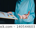 Business professional presenting data sheet with colorful graphs and charts during a corporate meeting session 140544603