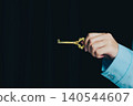 Success key concept. Golden Key Held in Hand Against Dark Background for Concept of Unlocking Secrets and Opportunities 140544607