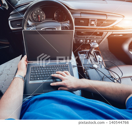 Mechanic man with laptop making car diagnostics at auto service Mechanic man with laptop making car diagnostics at auto service 140544766