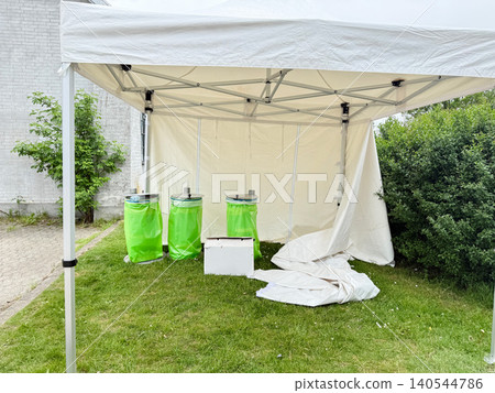Temporary event infrastructure with canopy shelter and utility containers on lawn Temporary event infrastructure with canopy shelter and utility containers on lawn 140544786