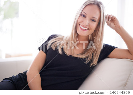 Portrait, happy and woman on a sofa relax with confidence, positive attitude or feel good mood in her home. Face, smile and female person in a living room with vacation, free time or resting holiday Portrait, happy and woman on a sofa relax with confidence, positive attitude or feel good mood in her home. Face, smile and female person in a living room with vacation, free time or resting holiday 140544869