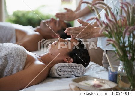 Hands, head massage and couple in spa to relax on bed for luxury pamper treatment together in hotel. Beauty, facial or zen woman with man at resort or salon for natural healing benefits or skincare Hands, head massage and couple in spa to relax on bed for luxury pamper treatment together in hotel. Beauty, facial or zen woman with man at resort or salon for natural healing benefits or skincare 140544915