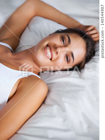 Portrait, relax and smile from woman on bed of apartment, comfortable and rest on soft mattress. House, morning and female person wake up from dream on pillow with happiness for break on weekend Portrait, relax and smile from woman on bed of apartment, comfortable and rest on soft mattress. House, morning and female person wake up from dream on pillow with happiness for break on weekend 140544987