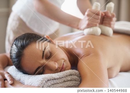 Relax, herbal compress and massage of woman at spa for skincare, peace or calm at luxury resort. Beauty, therapy and masseuse with bag at salon for body treatment, health or hands of person on back 140544988