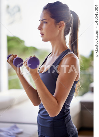 Gym, woman and dumbbells for fitness, wellness and training for workout indoors in house, home and apartment. Female person, athlete and strong with weights for exercise, health and vitality Gym, woman and dumbbells for fitness, wellness and training for workout indoors in house, home and apartment. Female person, athlete and strong with weights for exercise, health and vitality 140545004