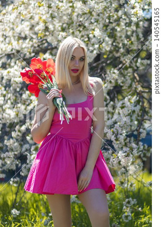 beautiful blonde in red dress with bouquet of flowers 140545165