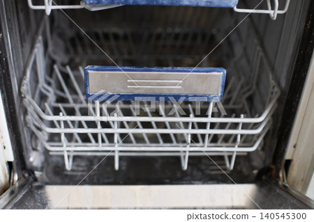 Empty dishwasher interior showing limescale and grime Empty dishwasher interior showing limescale and grime 140545300