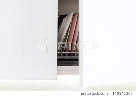 Kitchen cabinet opening displaying stacked drying plates Kitchen cabinet opening displaying stacked drying plates 140545305