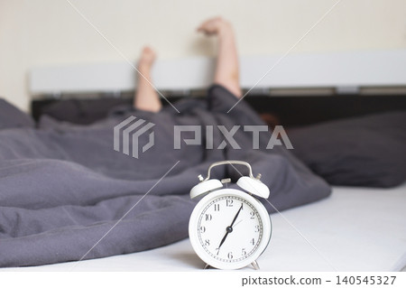 Young sleepy person waking up early in the morning stretching arms Young sleepy person waking up early in the morning stretching arms 140545327