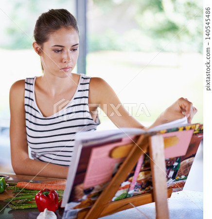 Cooking, book and kitchen with woman, vegetables and vegetarian with recipe and ingredients. Home, girl and person with skills and nutrition with diet plan and lunch with healthy meal and wellness 140545486
