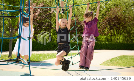 Children climbing rope playground equipment together in sunny park. Children climbing rope playground equipment together in sunny park. 140545629