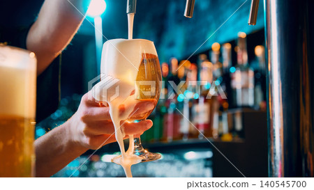 Female hand holding draft beer glass with foam spilling over rim. Female hand holding draft beer glass with foam spilling over rim. 140545700