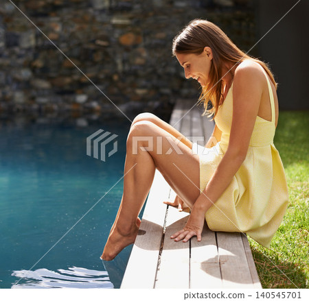 Happy, woman and relax with feet in pool on summer, holiday or vacation in California. Girl, smile and sitting outdoor on deck in backyard or garden with legs in water with casual style or fashion Happy, woman and relax with feet in pool on summer, holiday or vacation in California. Girl, smile and sitting outdoor on deck in backyard or garden with legs in water with casual style or fashion 140545701
