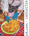Pogacha bread is served by woman in folk costume at food stand during Rose Festival in Kazanluk, Bulgaria. Pogacha shows baking tradition, bulgarian cuisine, national heritage 140545729