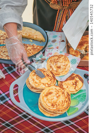 Pancakes are served with banitsa and pastry on table during Kazanluk Rose Festival food event in Bulgaria. Pancake recipe, bakery tradition, festival cuisine, community sharing Pancakes are served with banitsa and pastry on table during Kazanluk Rose Festival food event in Bulgaria. Pancake recipe, bakery tradition, festival cuisine, community sharing 140545732