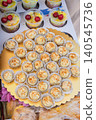 Cheese balls with nuts sit on gold tray beside fruit cups at Kazanluk Rose Festival food event. Cheese snack display shows catering. Dessert selection shows sweets, bakery products 140545736