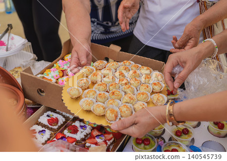 Desserts at Kazanluk Rose Festival food event. Hands present desserts and pastries at Kazanluk Rose Festival food event in Rosarium Park. Bakery craft, sweets, sharing, catering, Bulgarian cuisine Desserts at Kazanluk Rose Festival food event. Hands present desserts and pastries at Kazanluk Rose Festival food event in Rosarium Park. Bakery craft, sweets, sharing, catering, Bulgarian cuisine 140545739
