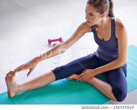 Serious, woman and stretching legs for pilates on mat at floor for exercise, wellness or healthy body. Yoga, flexible and foot of person in gym for fitness, warm up or practice for physical activity Serious, woman and stretching legs for pilates on mat at floor for exercise, wellness or healthy body. Yoga, flexible and foot of person in gym for fitness, warm up or practice for physical activity 140545814